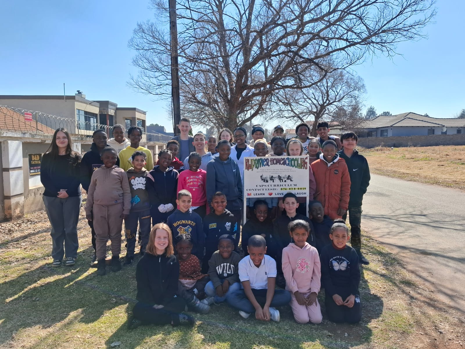 Kliprivier Homeschool community - students and teachers with school banner